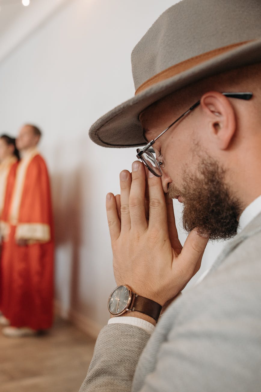 photo of a man with a hat praying